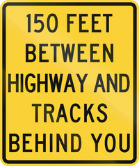 United States MUTCD road sign - 150 feet between highway and tracks behind you