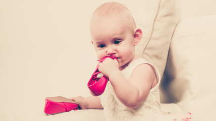 Baby girl biting shoe