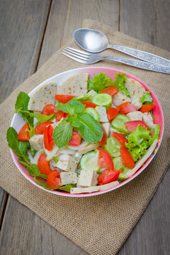 Thai cuisine spicy pork salad on wood background or Yum Moo Yor