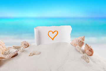 heart symbol on paper with sandy beach