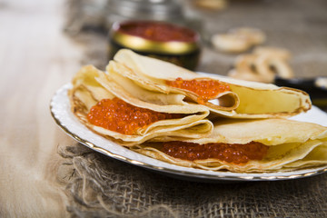 Pancakes with red caviar on a table