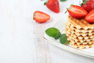 Waffles, mint and ripe strawberries.