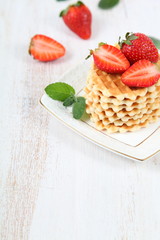 Waffles, mint and ripe strawberries.