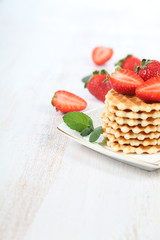 Waffles, mint and ripe strawberries.