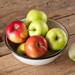 Red and green juicy apples placed in a bowl