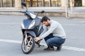 Fototapeta na wymiar Mann schraubt am Rad des Mopeds