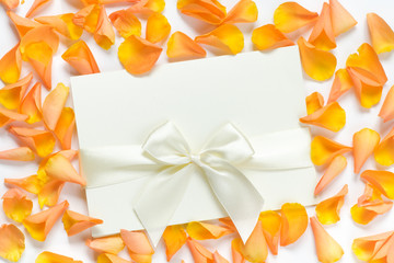 card with ribbon and rose petals