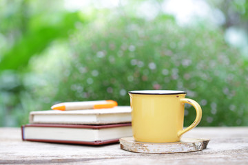 Notebook with pencil yellow mug on wooden table