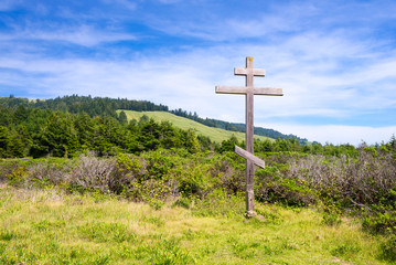 Fototapeta na wymiar old wood cross with hills on background
