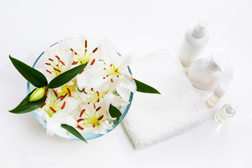 Flowers of white lilies in a round bowl with towel