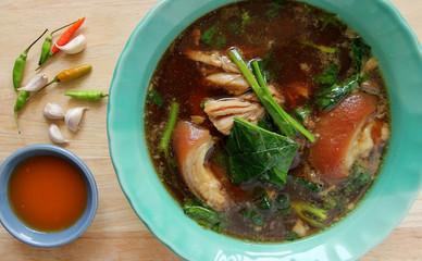 Stewed pork leg with side bowl on wooden table.Thai food