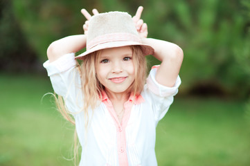 Cute kid girl having fun outdoors. Looking at camera. Smiling child. Childhood. 