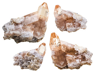 four topaz crystals on rocks isolated on white