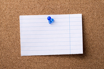 Blank teared note paper pinned on bulletin board