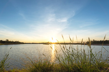Sunset landscape with fluffy cloud over the calm lake