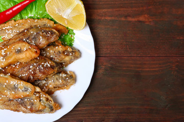 closeup of a plate with spanish boquerones fritos, battered and fried anchovies typical in Spain, on a rustic wooden table