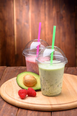healthy smoothie drink with avocado and raspberries on wooden board