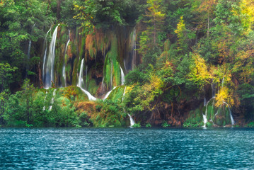 Croatia. Plitvice Lakes. Waterfall on a hillside near the lake with autumn trees