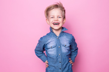 Portrait of happy joyful beautiful little boy. Studio portrait over pink background