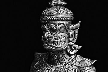 Buddhist stone statue. Giant guardian on black background