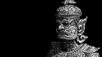 Buddhist stone statue. Giant guardian on black background