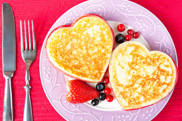 Time to celebrate. Homemade heart shaped pancakes with berries