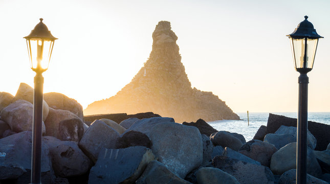 Acitrezza harbor at sunrise with old lamp
