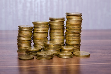 Stacks of euro golden coins on wooden table