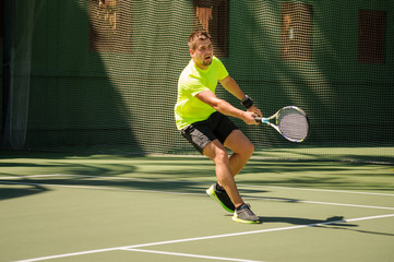 Man plays tennis in bright cloth