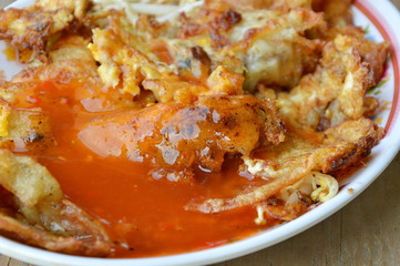 fried mussel omelet dressing chili sauce on dish