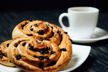 Tea and homemade bakery with chocolate on dark wooden table.