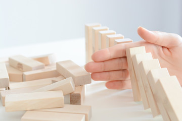 Stopping the domino effect concept with a business solution and intervention - obrazy, fototapety, plakaty