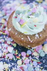 Fototapeta na wymiar cupcake with green cream and sprinkles