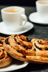 Tasty pretzels and two cups of tea on dark wooden table