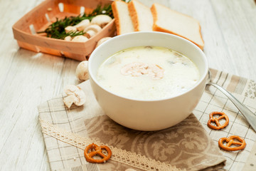 
mushroom soup with potatoes , carrots , green and white toast on a wooden background