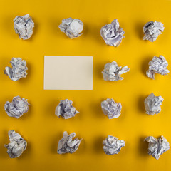 Crumpled paper balls and blank sheet of paper with pencil on yellow background. Paper wad. Creativity problems. Searching ideas.