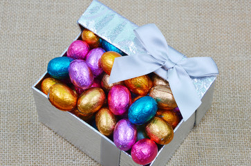 colorful chocolate in gift box on sack background