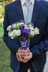 groom hold wedding bouquet in hand