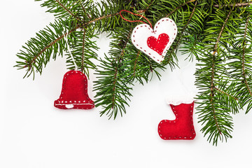 Christmas decorations made from felt on a twig spruce and white backgound
