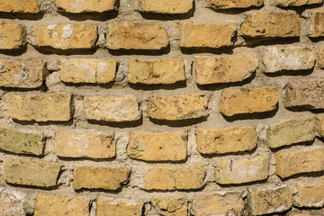 A pattern of yellow bricks with hard shadows