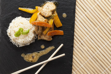 preparing asian food cooking ingredients chicken and vegetables on black slate plate
