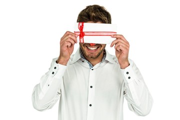 Handsome man covering eyes with gift box