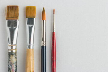 Artist paint brushes on canvas background