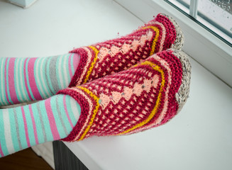 feet in warm socks on a windowsill