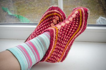 feet in warm socks on a windowsill