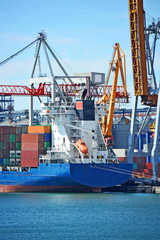 Fototapeta premium Container stack and ship under crane bridge
