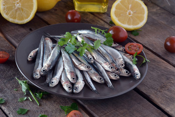 fresh anchovies, placed on a wooden table