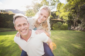Husband giving piggy back to wife