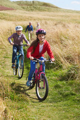 Obraz premium Grandparents With Children Cycling Through Countryside