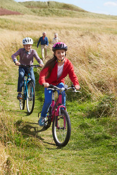 Grandparents With Children Cycling Through Countryside